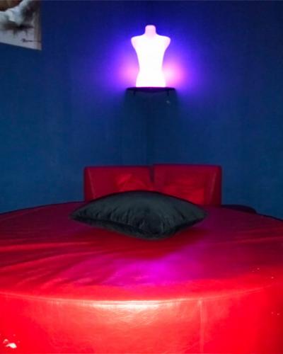 Coin calin de l'Elyx Club, ici un grand lit rond glamour pour de multiple expériences coquines